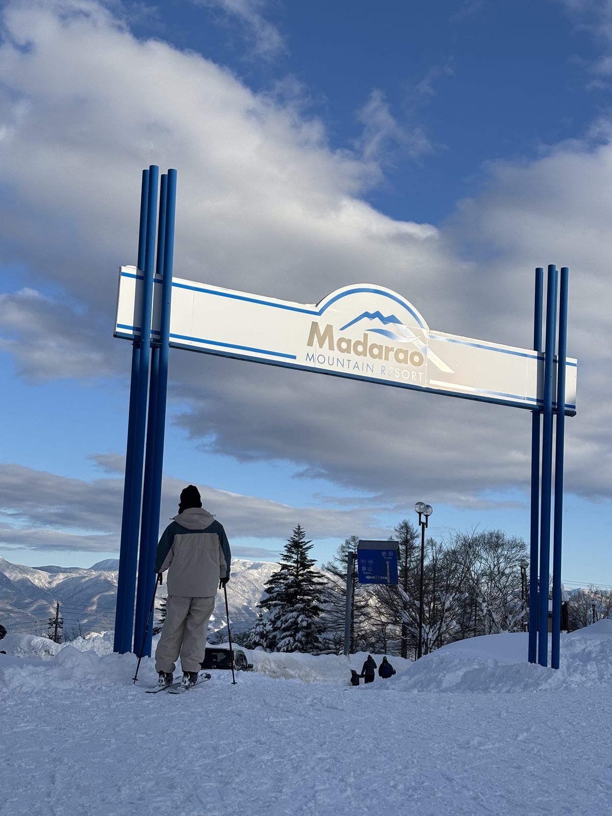 ゲレンデトップの「Madarao」の看板と青空、雪山