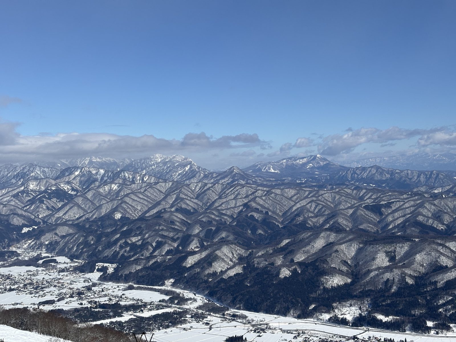 幾重にも連なる雪の山並みと、谷あいの集落